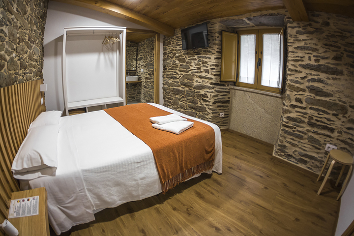 Habitación doble Hotel O Pozo con cama matrimonial y decoración rústica