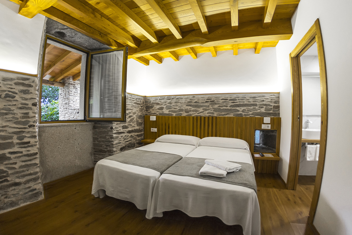 Habitación Hotel O Pozo con techos de madera y piedra vista
